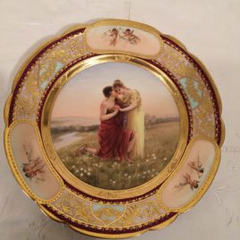 Royal Vienna plate painted with lovers and a border of three medallions of cherubs.