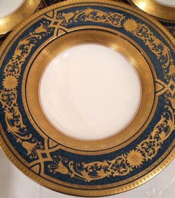 Close up of Royal Worcester blue plates with raised gilding wide rim soup bowls