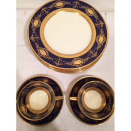 Five cobalt Minton dinner plates and two cream soups and saucers, all with profuse raised gilding.