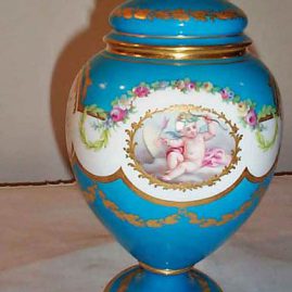 Other side of Minton cherub vase in the style of Sevres with rose finial