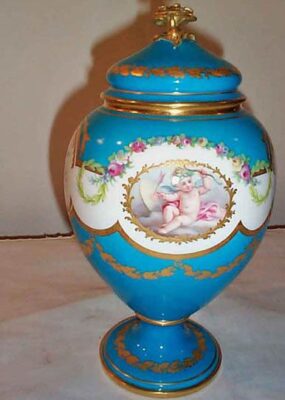 Other side of Minton cherub vase in the style of Sevres with rose finial