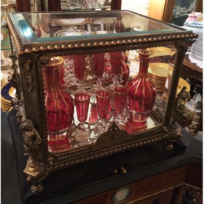 Rare bronze and beveled glass tantalus flanked with a figural putti on each corner