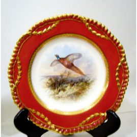 Close up of Wedgwood bird plate from the plates in the top row. Each is artist signed J. H Plumber