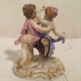 Back of Meissen girl and boy putti dancing with flowers