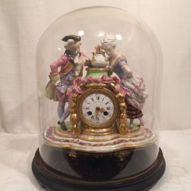 French figural clock with glass dome and wooden base. Late 19th century