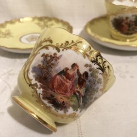 One of ten Meissen yellow cup and saucers with lovers