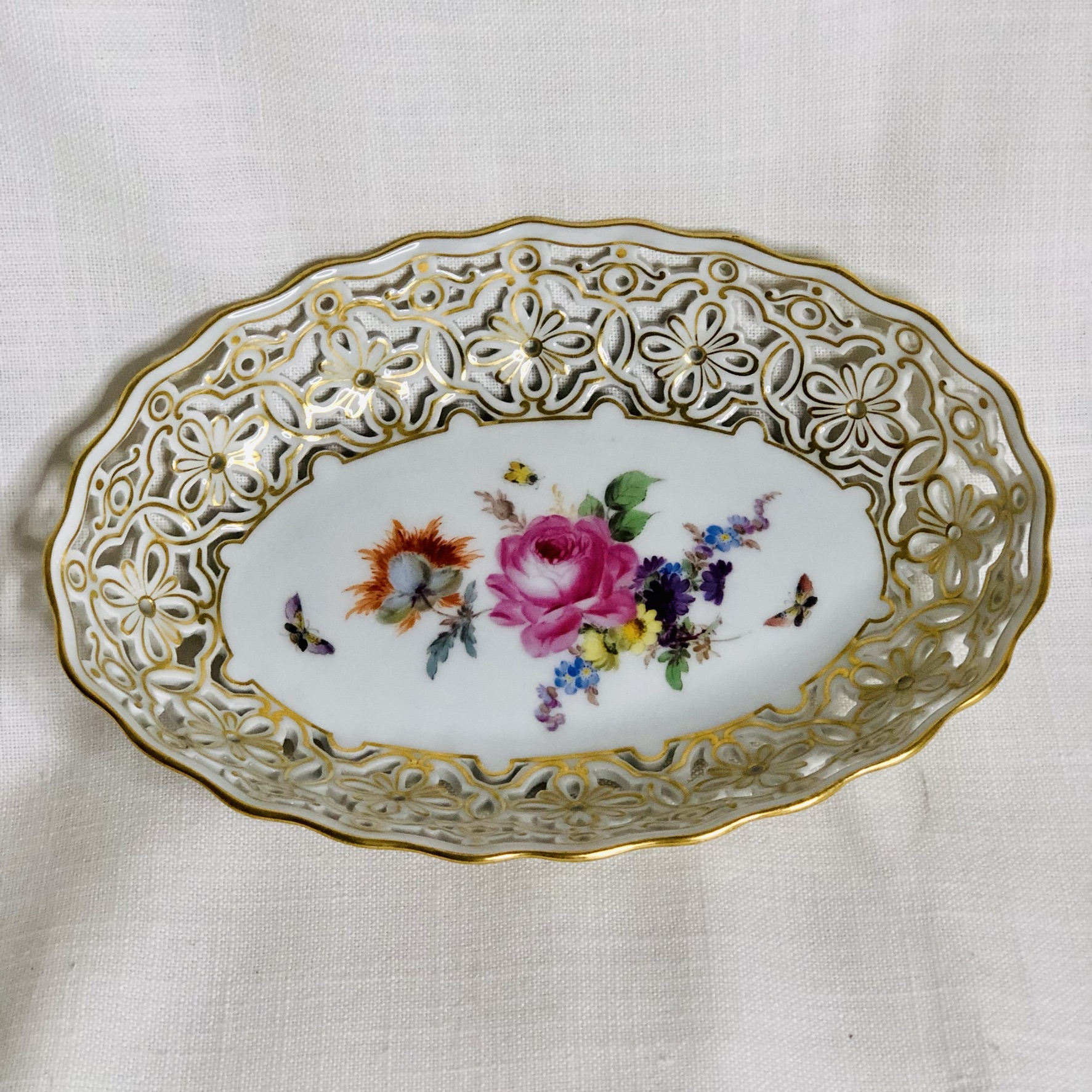 Oval Meissen reticulated bowl hand painted with a central painting of a flower bouquet Oval Meissen reticulated bowl hand painted with a central painting of a flower bouquet