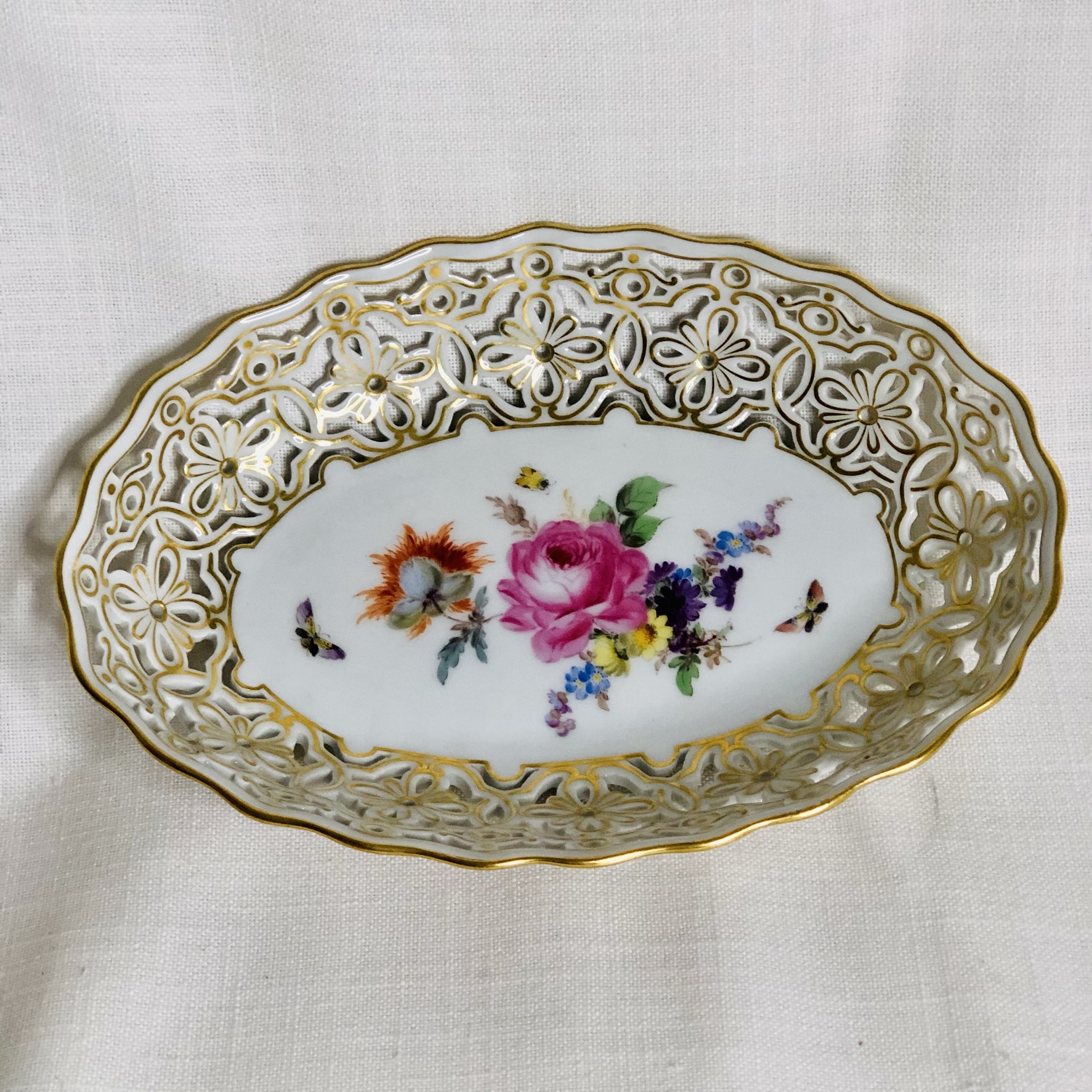Oval Meissen reticulated bowl hand painted with a central painting of a flower bouquet Oval Meissen reticulated bowl hand painted with a central painting of a flower bouquet