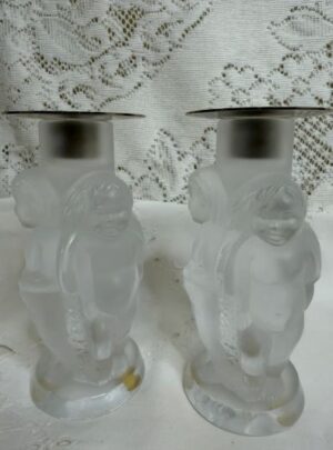 pair of Lalique iridescent Angelot candlesticks, where there are three figural decorative angels on each candlestick