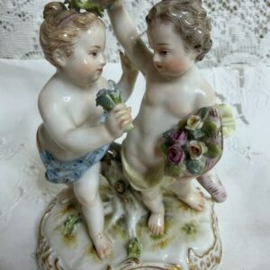 Meissen figural group of a boy holding a cornucopia full of flowers and a garland with a girl holding a flower bouquet.
