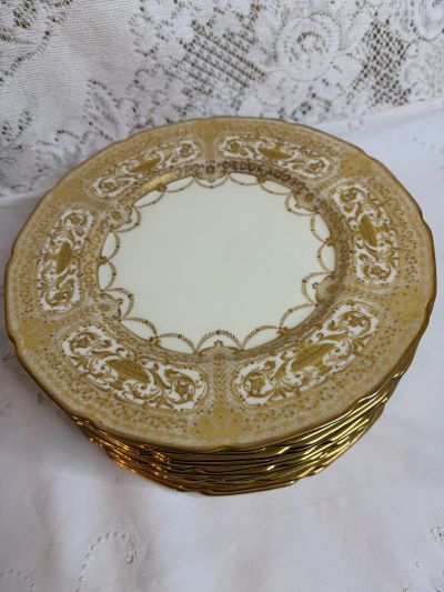 Set of Twelve Royal Doulton Dinner Plates that have Raised Profuse Gilding on a White Background
